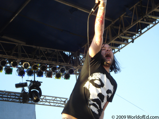 Bert from The Used with his arm in the air singing.