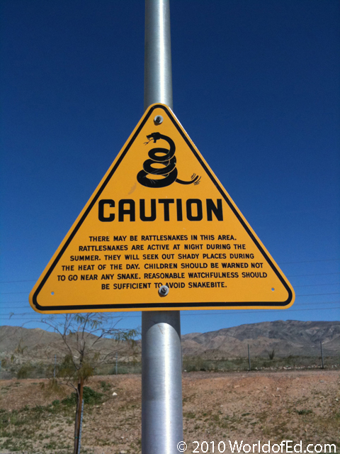 A sign warning of poisonous snakes at a rest stop.