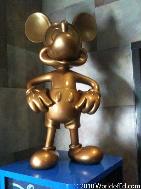 A gold statue of Mickey Mouse on a blue base.