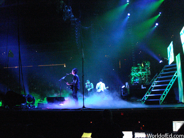 Synyster Gates playing guitar on stage.