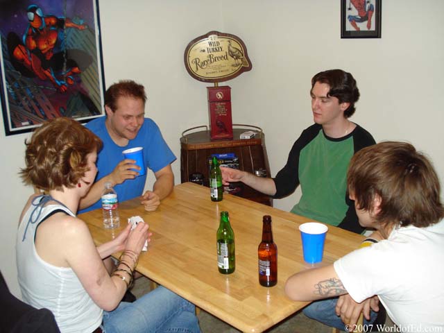 A group of people sitting at a table and playing cards.