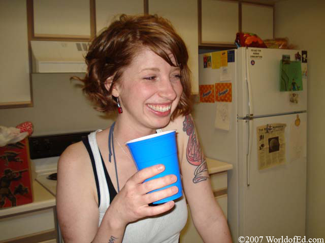 A woman holding a cup of alcohol.
