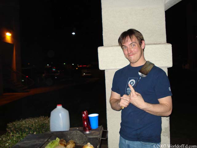 Ed holding a spatula and grilling.
