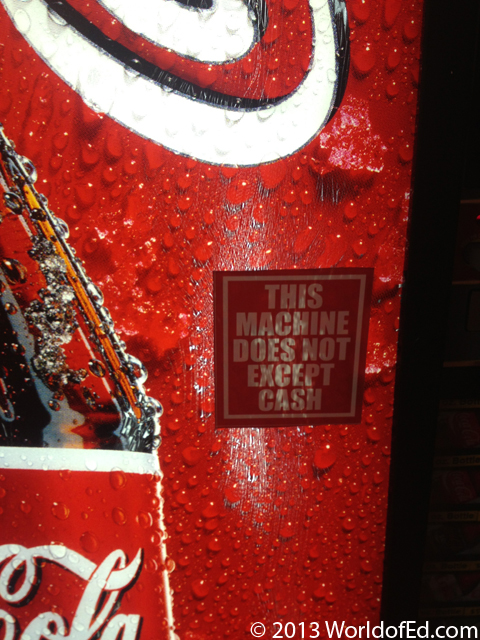 A Coke machine with a sticker on it.