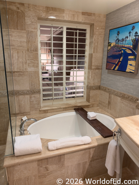 A large bathtub with a window over it.