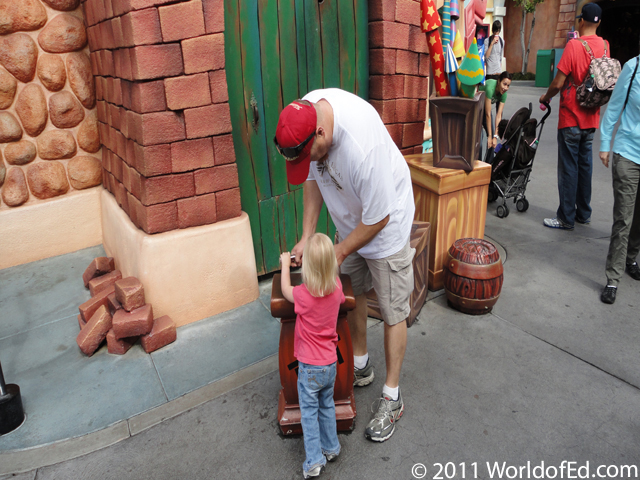 Megan depressing a plunger in front of a shop.