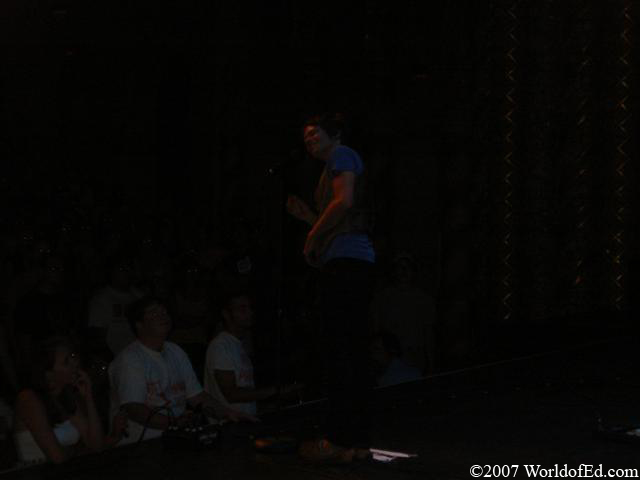 Nate Reuss standing on stage and talking to the crowd.