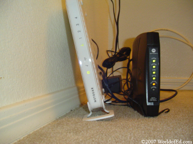A modem and router sitting on a floor.