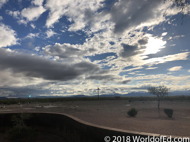 Clouds and desert from the side of the road.