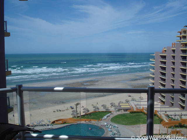 A picture of the ocean from a tall balcony.