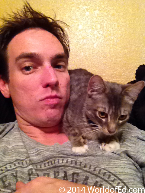 A gray tabby cat on Special Ed's shoulder.
