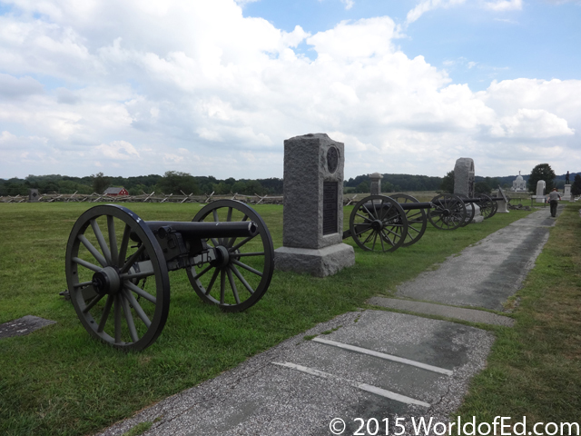 A line of cannons on a grassy field.