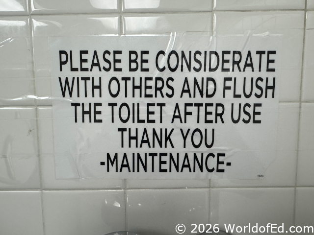 A sign asking patrons to flush the toilet.