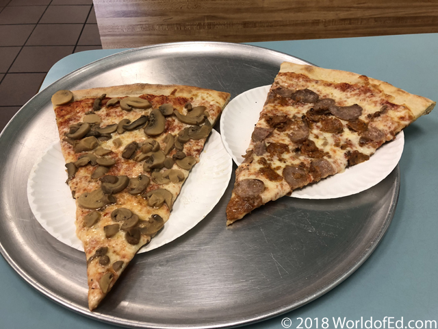 Two slices of pizza on two plates.