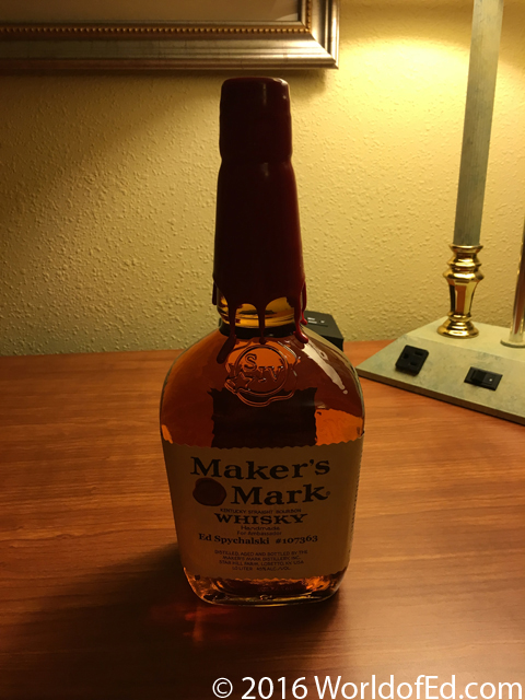 A custom bottle of Makers Mark on a hotel desk.