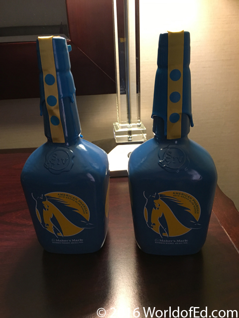 Two custom bottles of Makers Mark on a hotel desk.