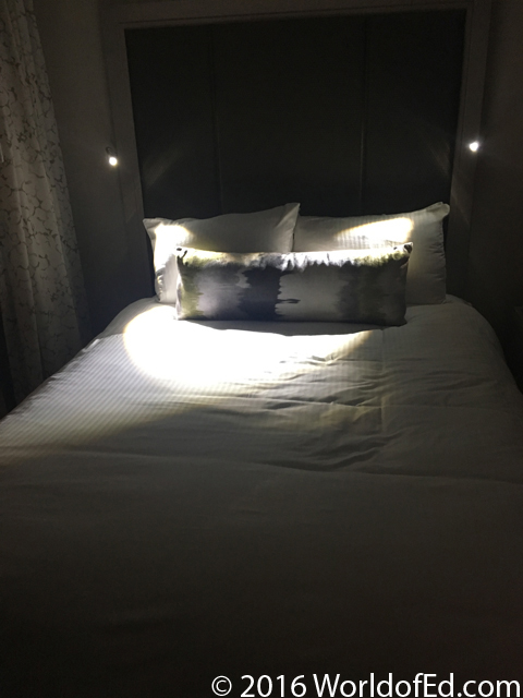A nice bed with bendable lights on the side.