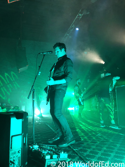 Gavin Caswell playing guitar in green light.